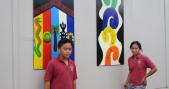 Students stand in front of their artwork