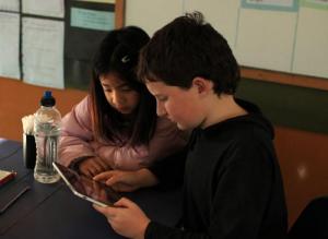 Students looking at an iPad.